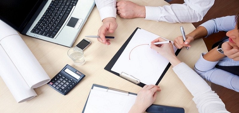 Picture of Hands of business people at the table at the meeting in the office, Overhead view with laptop and calculator on table.